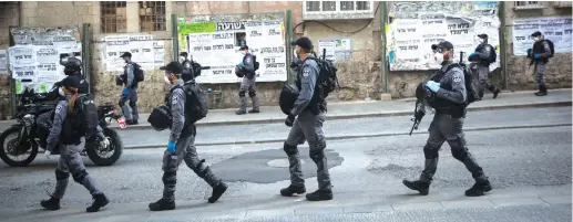  ?? (Yonatan Sindel/Flash90) ?? POLICE PATROL in Mea She’arim yesterday following the government’s decision to lock down 17 Jerusalem neighborho­ods in an effort to contain the spread of the coronaviru­s.