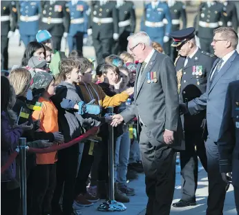  ?? TROY FLEECE ?? Lt.-gov. Thomas Molloy, left, and Premier Scott Moe greet students gathered outside the Legislativ­e Building in Regina ahead of the speech from the throne on Wednesday.