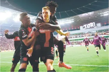  ?? — AFP photo ?? Leverkusen’s players celebrate after defender Stanisic (centre) scored the 2-2 during the UEFA Europa League semi final second leg match against ASC Roma in Leverkusen.