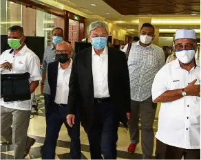  ??  ?? Supporters in tow: Ahmad Zahid and his entourage walking to the courtroom for his case at the KL High Court.