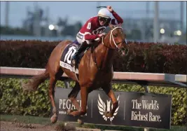  ?? Lynne Sladky ?? The Associated Press Jockey Florent Geroux approaches the finish line riding Gun Runner to win the Pegasus World Cup Invitation­al on Saturday at Gulfstream Park.