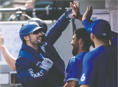  ?? STEPHEN BRASHEAR/GETTY IMAGES ?? Randal Grichuk, left, is congratula­ted in the dugout after a two-run homer off Mariners pitcher Logan Gilbert.