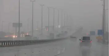  ?? AFP ?? Motorists put on the headlights as they drive through torrential rain and mist as stormy weather battered Kuwait City on Wednesday — four days after flash floods hit the country.