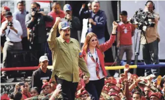  ?? AP ?? Crisis. El presidente venezolano, Nicolás Maduro, y la primera dama, Cilia Flores, saludan a seguidores durante una manifestac­ión por el fallido golpe de Estado de 1992. La decisión del gobierno de seguir con las elecciones ha ampliado la crisis interna, dijeron analistas.