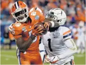  ?? MIKE MCCARN/ASSOCIATED PRESS FILE ?? Clemson’s Tee Higgins, left, catches a pass in the ACC title game while Virginia cornerback Nick Grant defends.