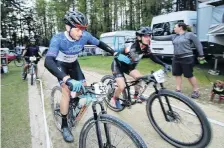  ??  ?? Ahead . . . Hefin Price (left), from the winning Smash It in the Dog team, is tapped by teammate Hannah Miller as he prepares to head out for another lap around the 11.6km course during the Naseby 12hour mountain bike race on Saturday.