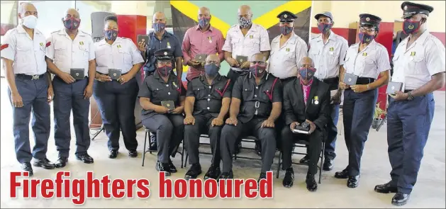  ?? (Photo: Llewellyn Wynter) ?? Fourteen members of the Area 3 Division of the Jamaica Fire Brigade were recently presented with medals of honour for long service and good conduct. The recipients, who pose here with their awards, include two district officers.