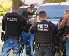  ?? DAMIAN DOVARGANES/ ASSOCIATED PRESS ?? U.S. Immigratio­n and Customs Enforcemen­t agents gather before a raid to arrest immigrants considered a threat to public safety and national security during an early morning raid in Compton, Calif.,.