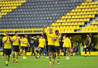  ?? MARTIN MEISSNER/AP PHOTO ?? Dortmund’s Erling Haaland, center, and his teammates celebrate at the end of the German Bundesliga soccer match between Borussia Dortmund and Schalke 04 on Saturday in Dortmund, Germany.