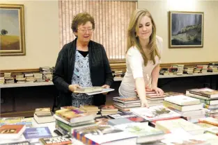  ?? ASSOCIATED PRESS FILE PHOTO ?? Clovis-Carver Public Library circulatio­n assistants Wanda Walters, left, and Jessica Thron prepare for a book sale last year in Clovis. Walters was killed and Thron was injured during a shooting at the library Monday.