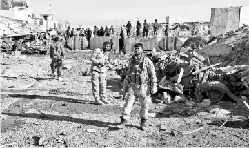  ??  ?? Afghan security personnel gather at the site of a suicide attack at a police compound in Maiwand district of Kandahar province. — AFP photo