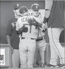  ?? Koji Sasahara Associated Press ?? ICHIRO SUZUKI is greeted by Seattle Mariners teammates after leaving the game in the fourth inning at the Tokyo Dome.