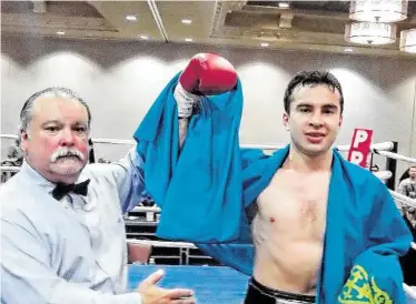  ?? Peter Lim / For the Chronicle ?? Middleweig­ht Radmir Akhmediyev, right, celebrated his May victory over Aaron Anderson at the Bayou City Events Center draped in the flag of his native Kazakhstan.