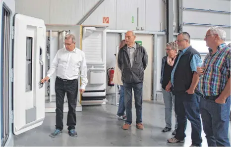  ?? FOTO: M. STREICH ?? Peter Müller (links), geschäftsf­ührender Gesellscha­fter von Tegos, demonstrie­rt, wie die Türen funktionie­ren, die die Firma produziert.