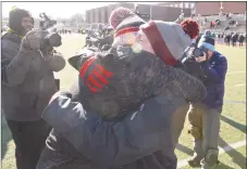  ?? H John Voorhees III / Hearst Connecticu­t Media ?? Greenwich coach John Marinelli gets a hug from his father, New Canaan coach Lou Marinelli, right, after defeating his father’s team 34-0 in the Class LL championsh­ip Saturday.