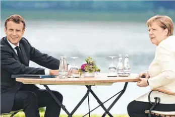  ?? FOTO: KAY NIETFELD/DPA ?? Mit dem gebotenen Abstand, aber in der Sache einig: Kanzlerin Angela Merkel am Montag in Meseberg mit Frankreich­s Präsident Emmanuel Macron.