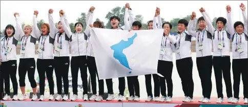  ?? KIM DO-HUN / YONHAP NEWS AGENCY VIA ASSOCIATED PRESS ?? Members of the inter-Korean team celebrate their victory during the medal ceremony for the women’s 500-meter dragon boat at the 18th Asian Games in Palembang, Indonesia,on Sunday.