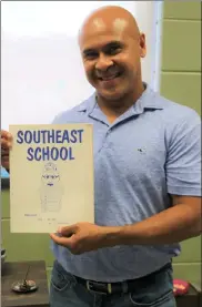  ??  ?? Principal Andres Vera holds the inspiratio­n for the time capsule, a 1978 school yearbook that mentions a time capsule buried on school grounds when Frances Drake first opened, the 1972-73 school year, that was due to be opened in 2023, 50 years later. They have been unable to locate that time capsule, so they decided to create a new one.