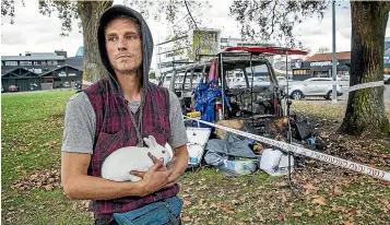  ?? WARWICK SMITH/STUFF ?? David Takimoana with his rabbit, Hasta, after the van he was living in and most of his belongings were destroyed by fire. Takimoana had been a regular camper on the Railway Land Reserve, after parking in The Square became untenable.