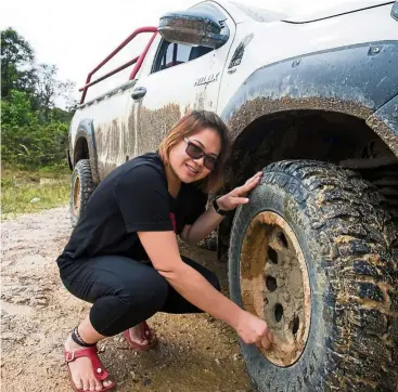  ?? — KEN ZHONG WONG ?? Learning to change tires and maintain her vehicle are skills that Johnson has learnt as a transporte­r who travels regularly between Miri and Bario.