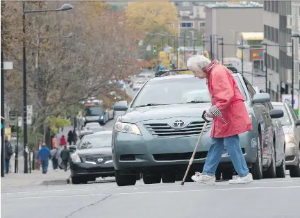  ?? ALLEN MCINNIS/MONTREAL GAZETTE ?? Making their way around the city can be a real burden for the elderly. The challenges include walking across intersecti­ons, as this senior does at Côte-des-Neiges and Côte St. Catherine streets, within the time allotted by the traffic light.