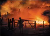  ?? THE ASSOCIATED PRESS ?? A firefighte­r extinguish­es flames from the Oak fire in Mariposa County last week.