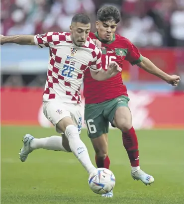  ?? ?? ↑ Croatia’s Josip Juranovic, left, and Morocco’s Abde Ezzalzouli challenge for the ball