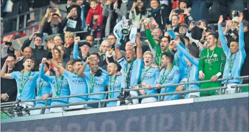  ??  ?? CELEBRACIÓ­N. Kompany, rodeado de sus compañeros, levanta la Carabao Cup, el primer título de Guardiola al frente del City.