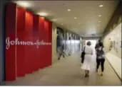  ?? THE ASSOCIATED PRESS ?? People walk along a corridor at the headquarte­rs of Johnson & Johnson in New Brunswick, N.J.