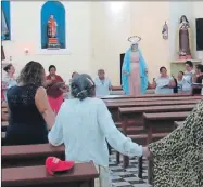  ??  ?? Devotas realizan el Rosario en honor a María Reina de la Paz, luego de su entrada (a la izquierda) a la parroquia de San Lorenzo en Yobáin la noche del jueves. El novenario mariano concluirá el próximo lunes