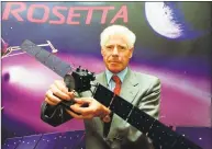  ?? Matthew Fearn / Associated Press ?? European Space Agency Director of Science Roger Bonnet holds a model of the Rosetta spacecraft, which is being prepared for a mission to the Comet Wirtanen.
