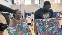  ?? IRA WINDERMAN/SUN SENTINEL ?? Heat center Bam Adebayo and his mother, Marilyn Blount, receive a commemorat­ive piece of artwork at his youth clinic in Kendall.