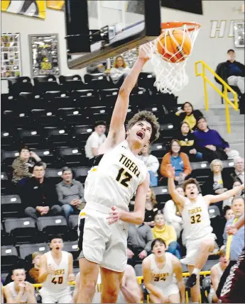  ?? MARK HUMPHREY ENTERPRISE-LEADER ?? Signature slam on senior night. The bench erupts witnessing Prairie Grove 6-feet-3 senior Landon Semrad slam dunk on Gentry with just seconds remaining. Semrad scored 20 points in the Tigers’ 67-48 boys basketball victory over the Pioneers on Tuesday, Feb. 1.