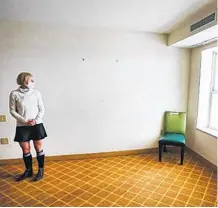  ?? POSTMEDIA NEWS ?? Dr Kerri Treherne looks out a window of a stripped down room at the assisted self-isolation hotel in Calgary on Thursday. The room is one of the larger rooms in the hotel. It has a large bedroom, bathroom and a kitchenett­e. The appliances in the kitchenett­e have been shut off for safety and practicali­ty reasons (clients have food and meds delivered and there is no need to cook or store food).