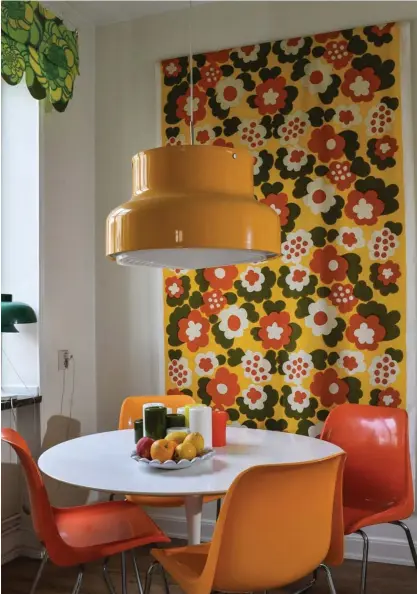  ?? FOTO: ANDERS WIKLUND/TT ?? Maria Jernkvist älskar sitt "karamellkö­k". På väggen hänger ett av hennes personliga favoritmön­ster, Floora av Kerstin Ratia från 1969. Färgskalan matchar stolarna och den klassiska lampan.