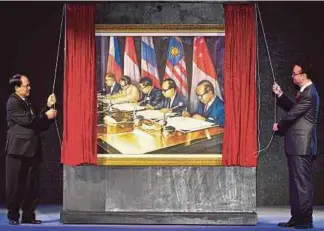  ??  ?? Philippine­s Foreign Secretary Alan Peter Cayetano (right) and Asean Secretary-General Le Luong Minh unveiling a painting of the founding fathers of the regional grouping during the opening ceremony of the 50th Asean Regional Forum meeting in Manila...