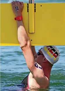  ?? UNCREDITED / DPA ?? Florian Wellbrock ist als Sieger für die deutsche Mixed-staffel im Freiwasser an der Anschlagpl­atte.