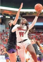  ?? ?? Louisville’s Olivia Cochran tries to make a basket against Washington’s Dalayah Daniels Wednesday night.