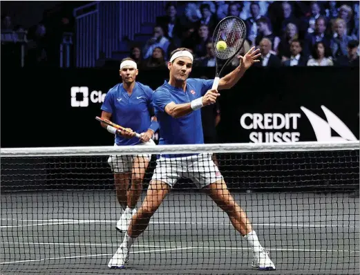  ?? CLIVE BRUNSKILL | GETTY IMAGES ?? Volea de Roger Federer, por delante de Rafa Nadal, durante el partido de dobles que ambos disputaron ayer en Londres.