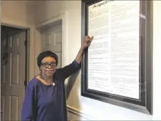  ?? AP PHOTO/MICHAEL WARREN ?? In this March 4, 2020 photo, Roslyn Pope poses with a framed copy of “An Appeal for Human Rights” in her home in Atlanta.