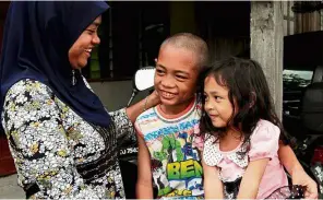  ??  ?? Reunited: Nurul Farhana happy to see her children Muhammad Fakhrullah and Fatini at home in Kampung Masjid Haji Kadir.