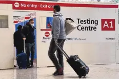  ?? FRANK AUGSTEIN/ASSOCIATED PRESS ?? Passengers get a COVID-19 test at Heathrow Airport in London. The Biden administra­tion is lifting its requiremen­t that internatio­nal air travelers to the U.S. take a COVID-19 test within a day before boarding their flights.