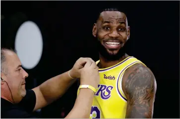  ?? AP PHOTO BY MARCIO JOSE SANCHEZ ?? Los Angeles Lakers’ Lebron James smiles as a microphone is placed on his chest during media day at the NBA basketball team’s practice facility Monday, Sept. 24, in El Segundo, Calif.