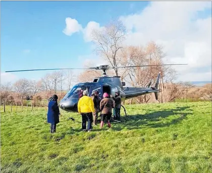  ??  ?? ALEX Chittock of Tararua Heliworks, the team and visitors flew up to the top of the Friel’s hill in Kumeroa.