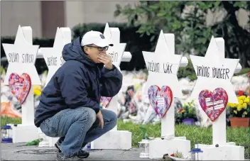  ?? AP PHOTO ?? A person pauses in front of Stars of David with the names of those killed in a deadly shooting at the Tree of Life Synagogue, in Pittsburgh Monday.