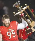  ?? THE CANADIAN PRESS ?? Laval Rouge et Or’s Vincent Desloges raises the Bruce Coulter Award for best defensive player after defeating the University of Calgary Dinos at the Vanier Cup final Saturday in Quebec City.