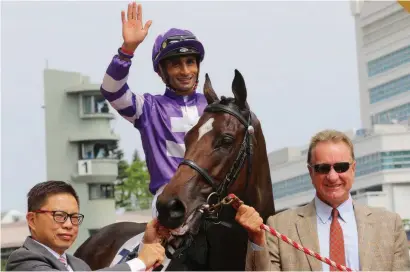  ?? Picture: Hong Kong Jockey Club ?? TOP TEAM: Strathalla­n and jockey Karis Teetan are greeted by trainer Tony Millard, right, after victory in the first race at Sha Tin at the weekend.