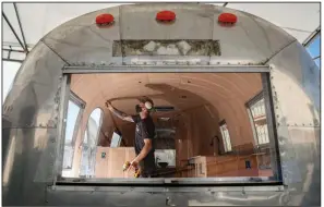  ?? (The Washington Post/Sandy Huffaker) ?? Carpenter Chris Witte works on custom wood walls inside an Airstream camper at So Cal Vintage Trailer in California.