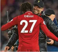  ?? Foto: afp ?? Ausgelasse­n herzt Liverpools Trainer Jürgen Klopp seinen Torschütze­n Divock Origi, der das 1:0 im Stadtduell gegen den FC Everton erzielt hatte.