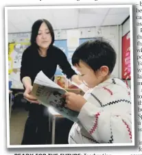  ??  ?? READY FOR THE FUTURE: Teacher Ling Fang Zhou helps pupil Pu Yuan Ge with his reading in front of the class.